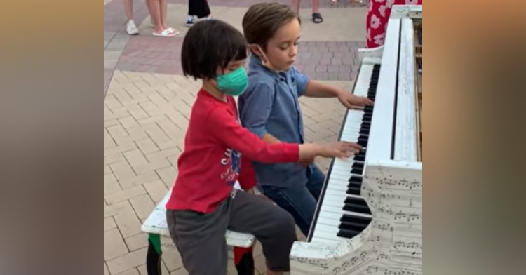 two six year old boys playing a public street piano at broadway plaza in california