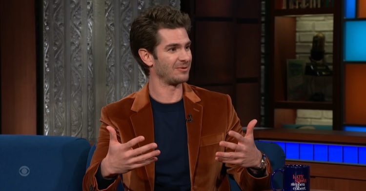 andrew garfield sitting on a couch and talking to stephen colbert on "the late show with stephen colbert"