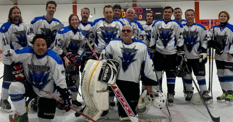 blind hockey player, nelson rego, posing with the rest of the sighted edmonton hockey team out on the ice