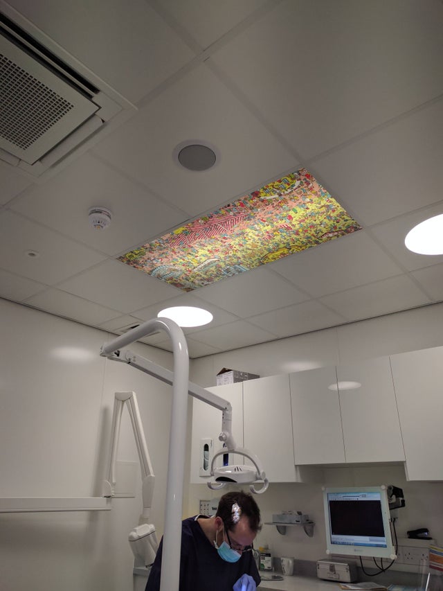 dentist working on a patient with one ceiling tile with a 
