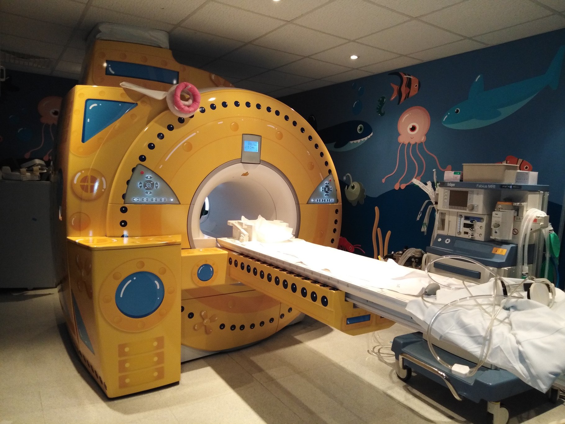 an mri machine decorated to look like a submarine that's inside of a room with walls painted with sea creatures