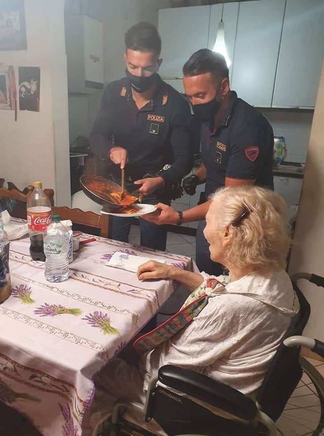 police officers feeding older lady at home