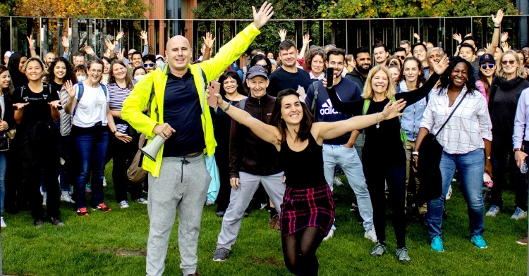 man named jake williams and a woman named charlotte sinclair smiling and posing with a large group of people for talk the walk