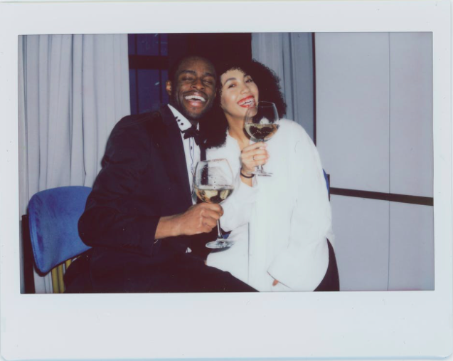 man and woman holding giant wine glasses and laughing