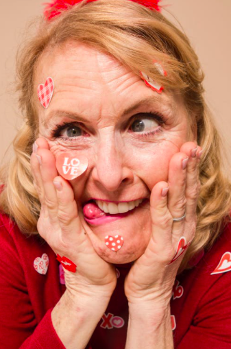 older woman making funny face with heart stickers all over her