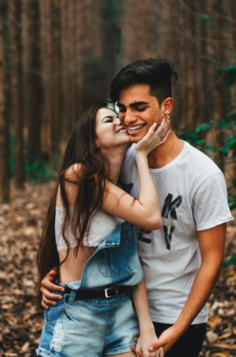 woman about to kiss man in forest