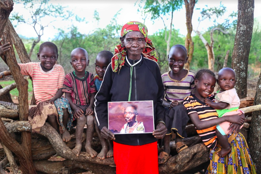 woman holding picture of herself with a cleft surrounded by six young children