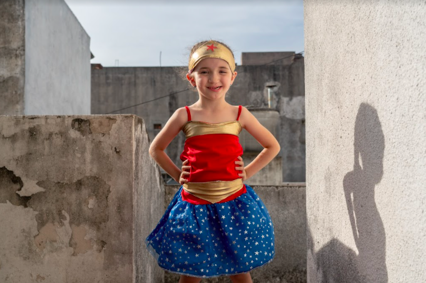 little girl wearing superhero costume