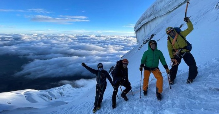 group of four people climbing the volcano cotopaxi in ecuador