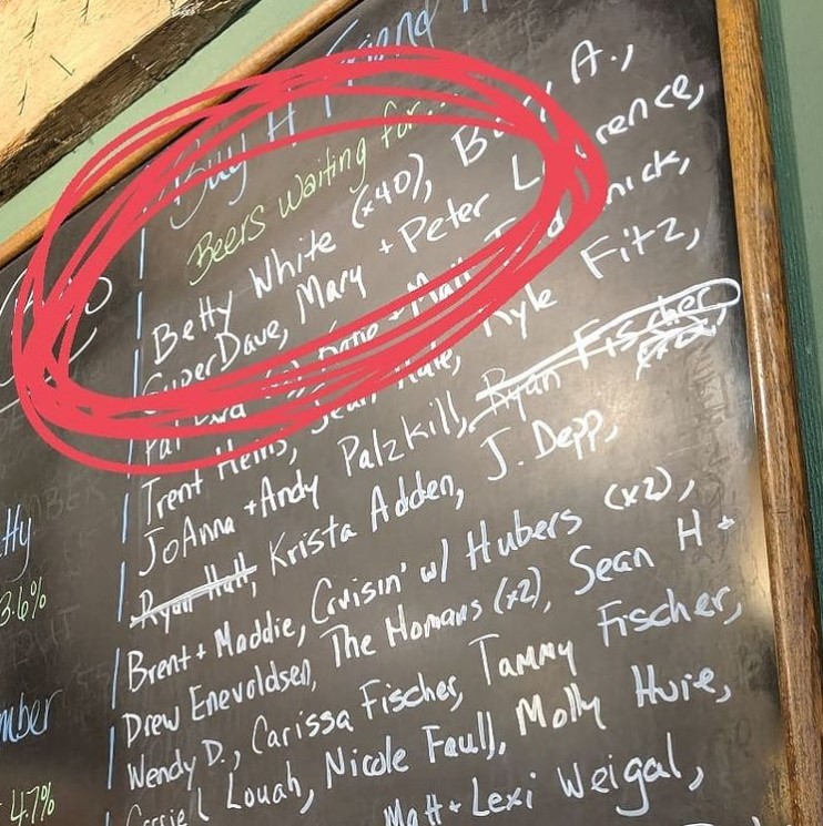 chalk board at commerce street brewery filled with named of people who have beers waiting for them including betty white whose name is circled with red