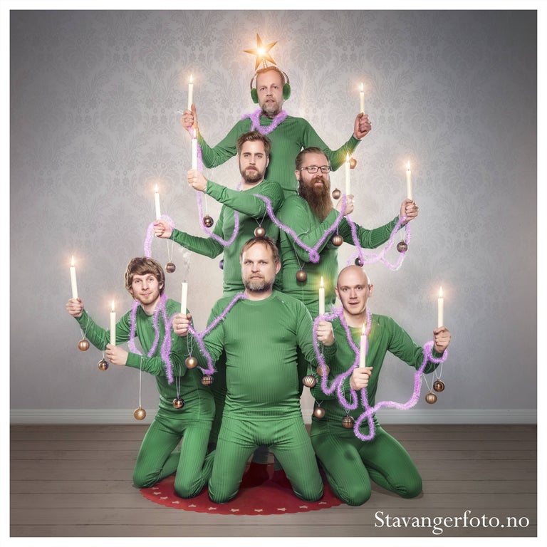 funny Christmas card photo of the employees dressed in matching green outfits forming a human Christmas tree