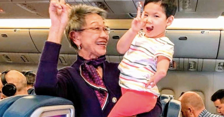 flight attendant holding little girl on plane