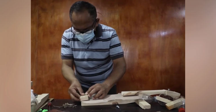 man making recycled violin