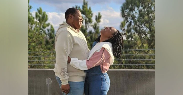 a woman named camille jones and a man named marlon jones facing each other as she hugs him and they both laugh while standing outside