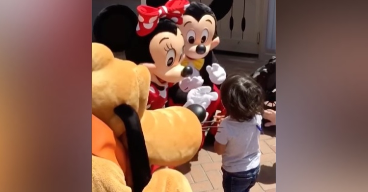 mickey and minnie mouse at disney world communicating with a deaf little boy using sign language