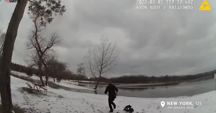 screenshot from a police officer's body cam footage where a man named jon smith is throwing off his equipment as he runs on snow toward a frozen lake to save a dog