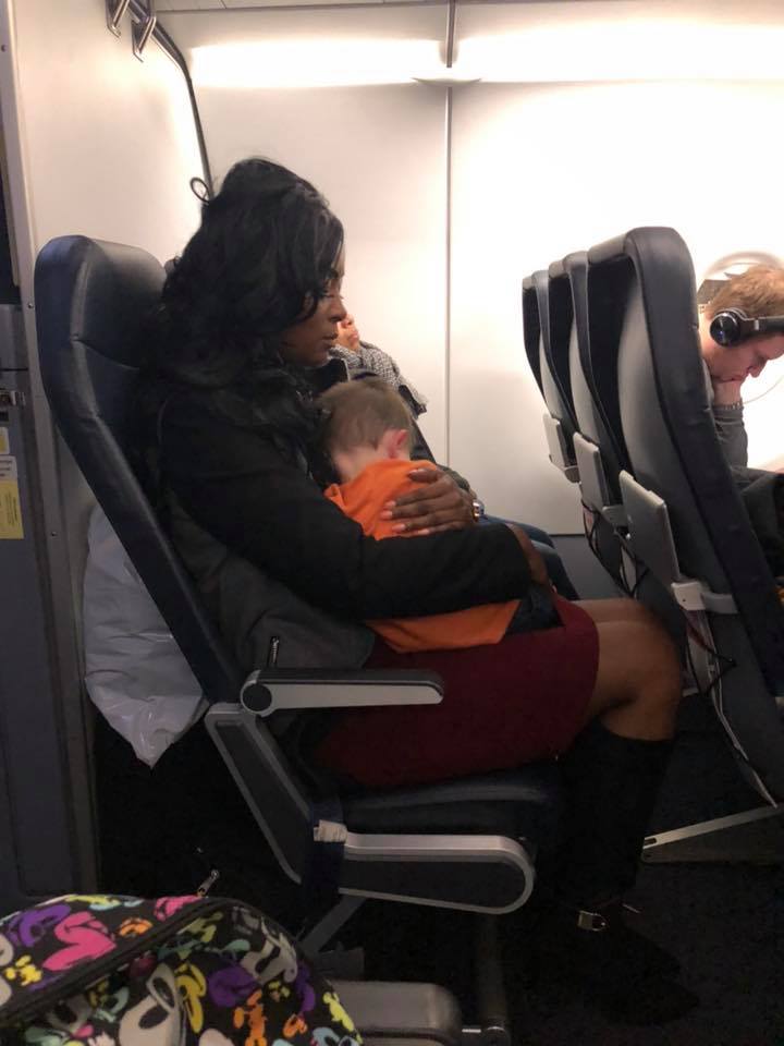woman holding stranger's baby on a plane