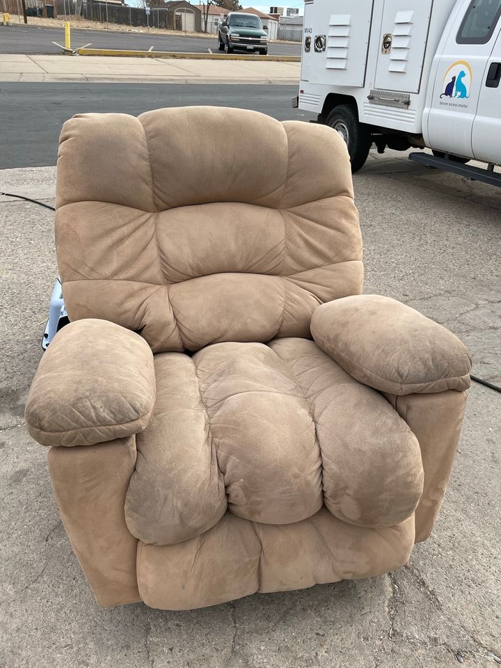 a large, light brown recliner sat outside of a thrift store in denver, colorado 