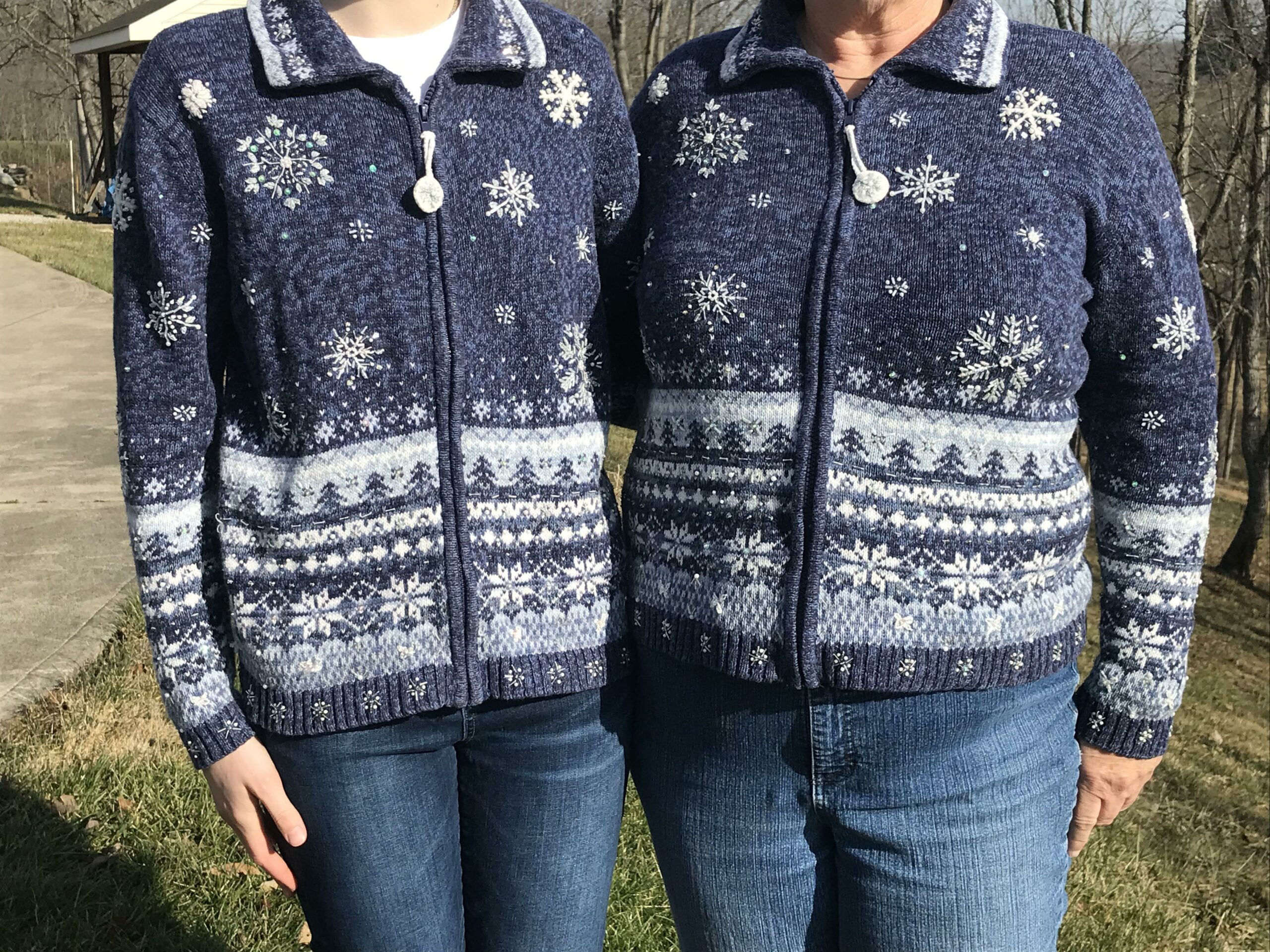 a mother and daughter posing together while wearing identical sweaters with snowflakes on them