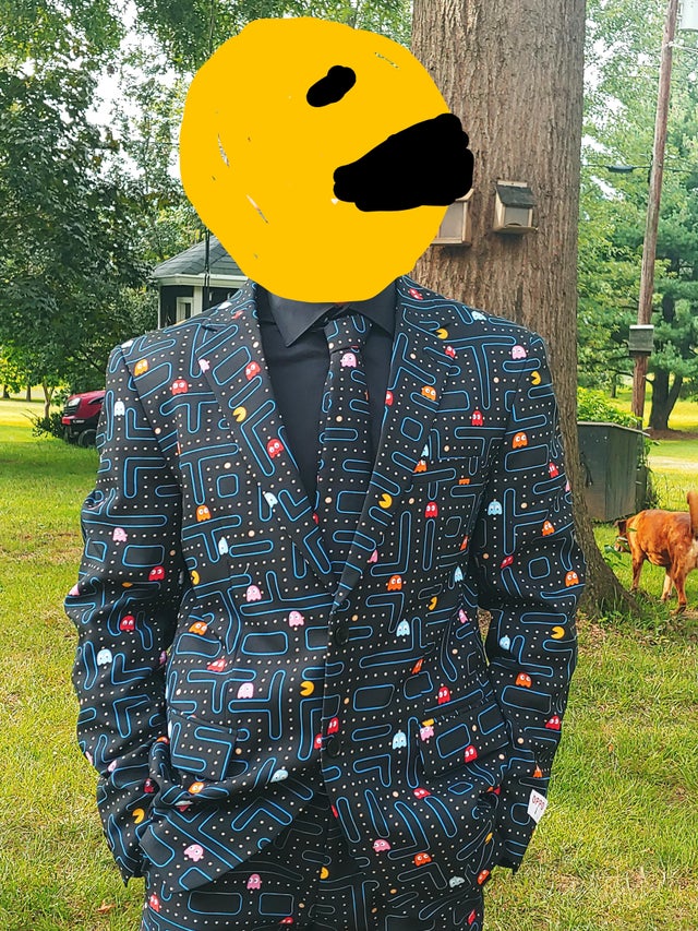 a man, whose face has been cover with a digital drawing of pac-man, wearing a pac-man suit 