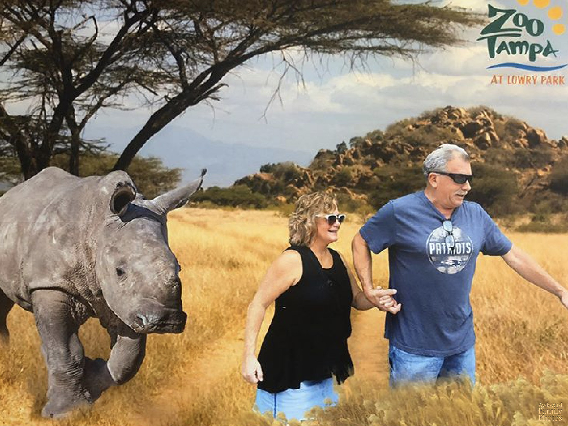 couple posing with rhino at zoo