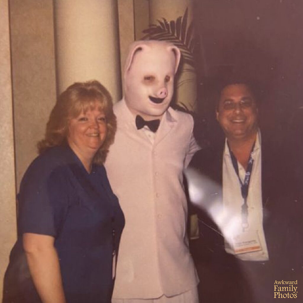 weird picture of couple posing with man in pig mask