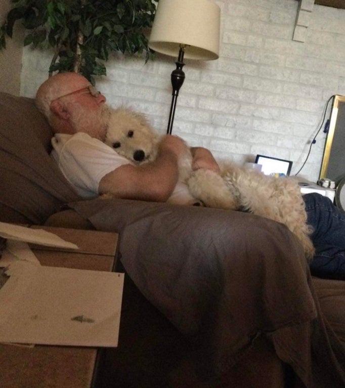 man cuddling with dog