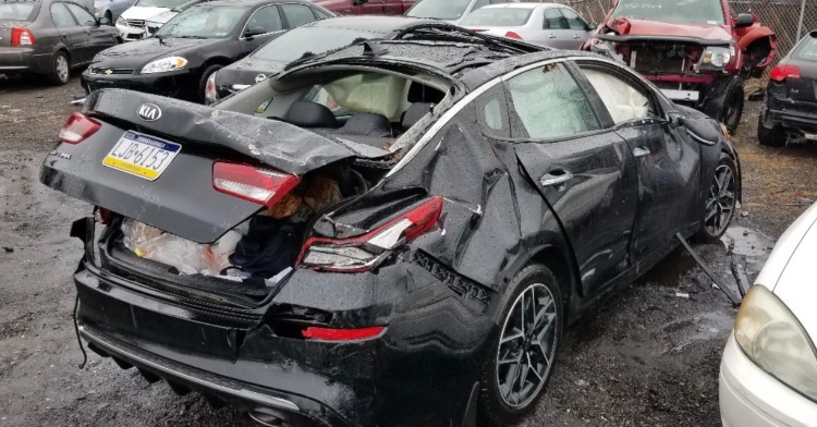 a totaled black car that was owned by a woman named pamela jones
