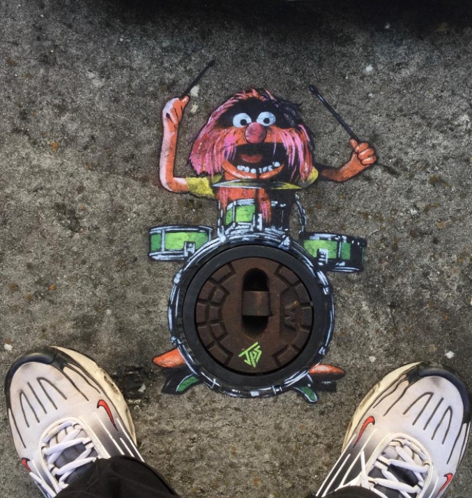 graffiti art by jps of the muppets character called monster who is playing the drums 