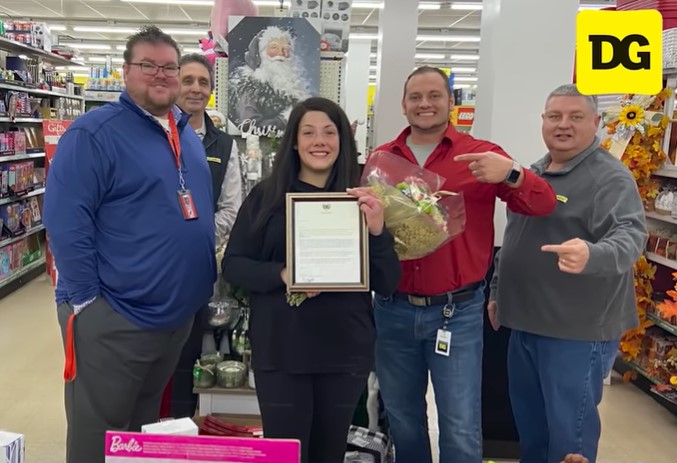 a group of five dollar general employees posing for a photo, including a woman named emily duncan who is holding a plaque that was given to her