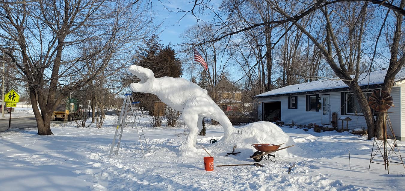 a 12 foot tall ice sculpture of a t-rex being built in paul larcom's front yard in minnesota 