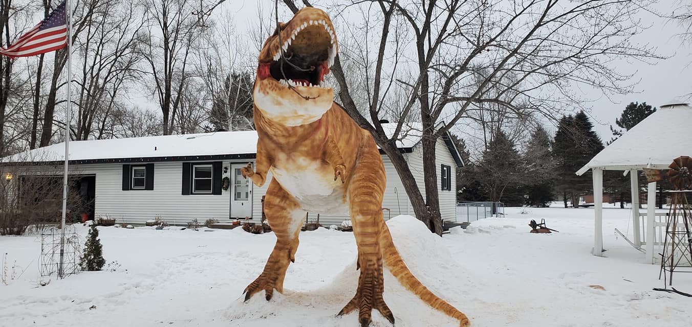 front facing view of a completed t-rex snow sculpture in paul larcom's front yard in minnesota 
