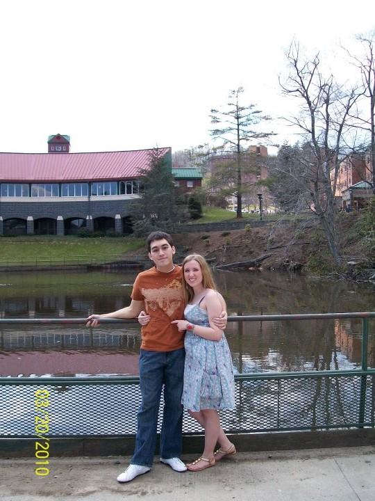 a young couple posing in front of the water in a photo dated 2010