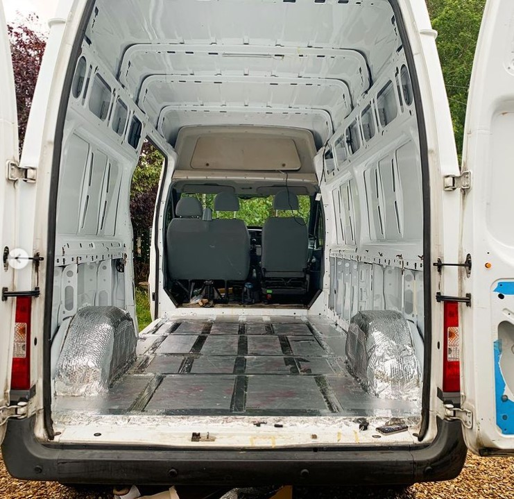 the inside of a large white van as seen through the opened back doors