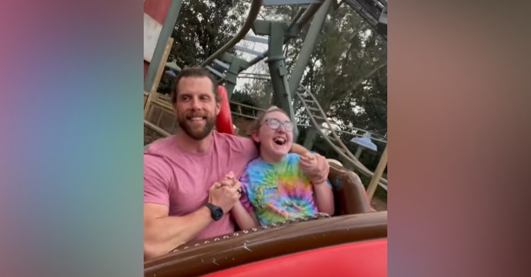 a girl with cerebral palsy named abby smiling as she and her dad ride a roller coaster in disneyland