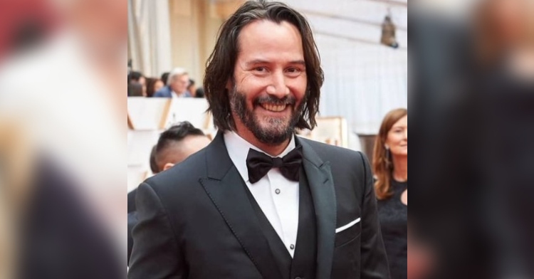 closeup of keanu reeves smiling as he walks on the red carpet for the academy awards 2020