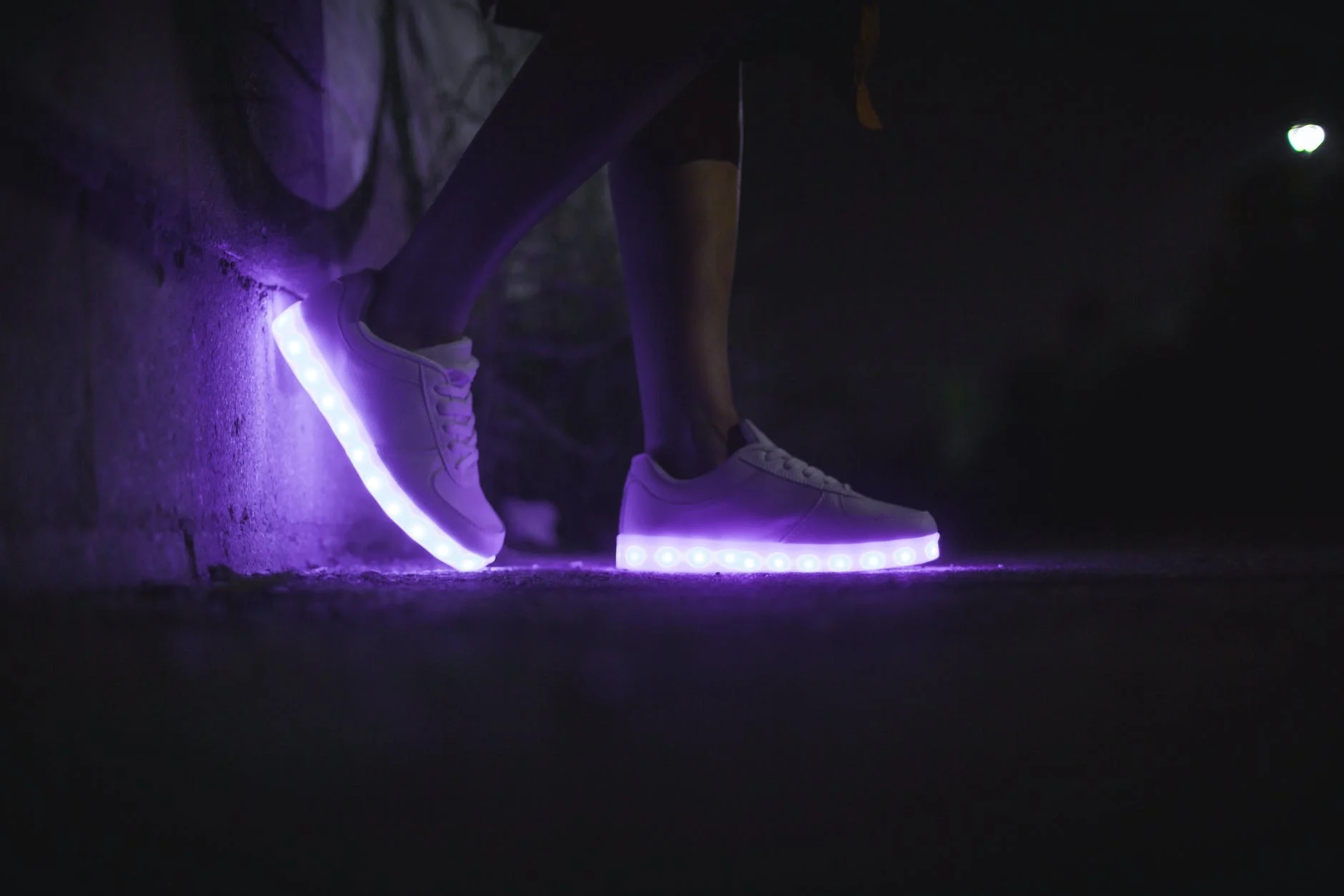 closeup at nighttime of a pair of purple led shoes that someone is wearing