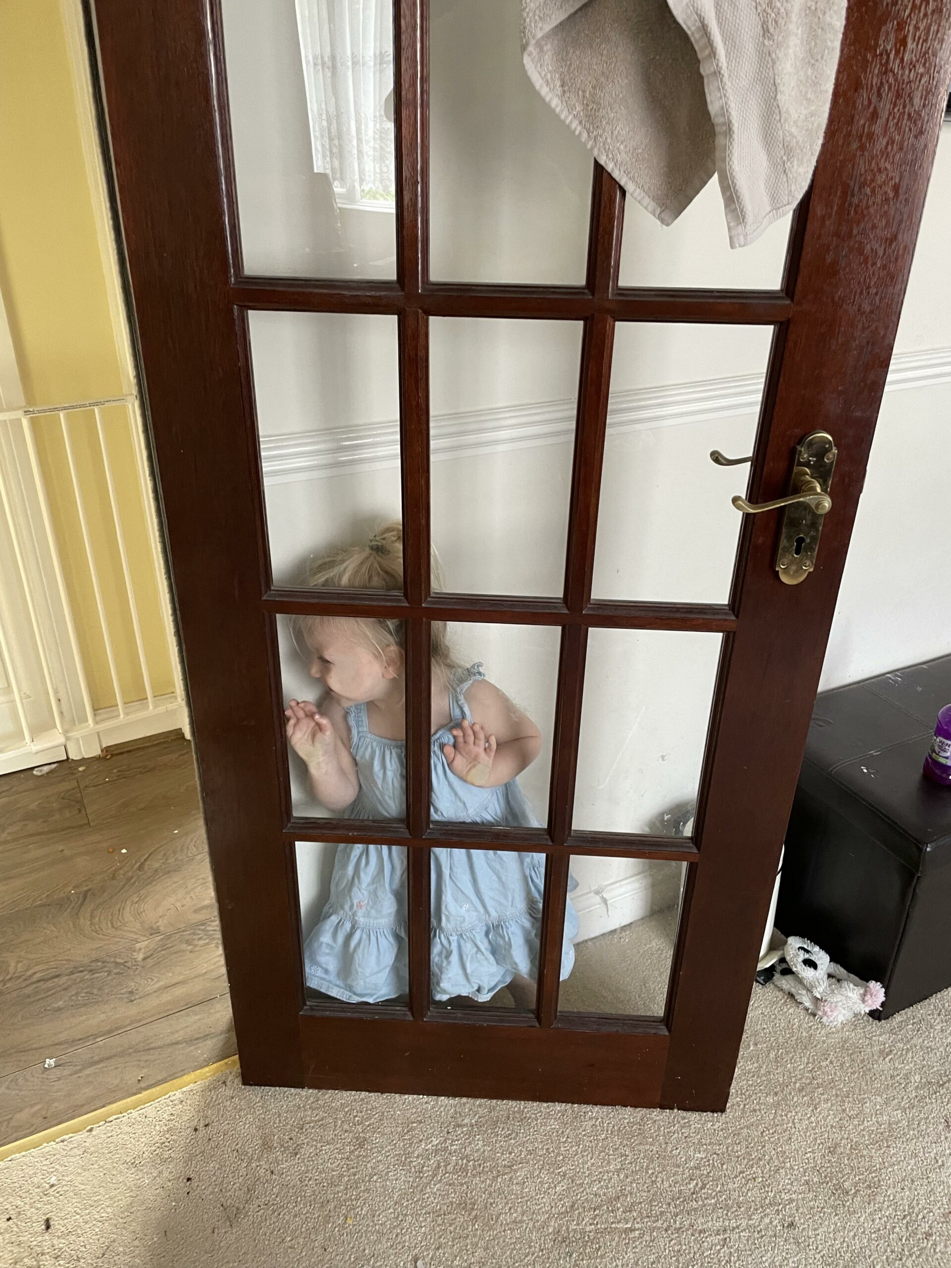 kid hiding behind glass door