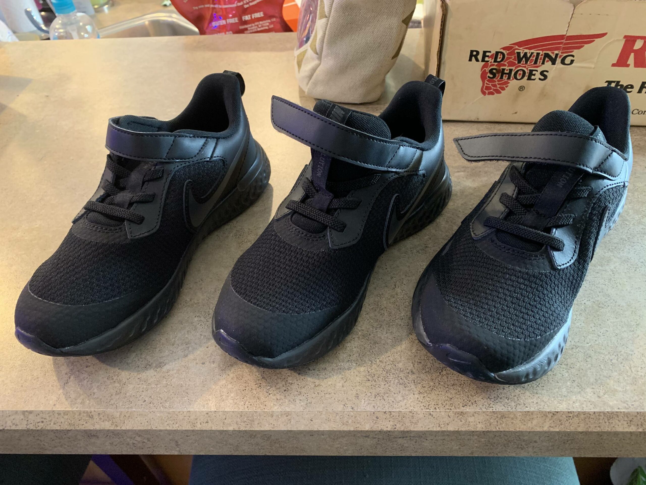 three of the same kind of black tennis shoe, all of which are for the right foot