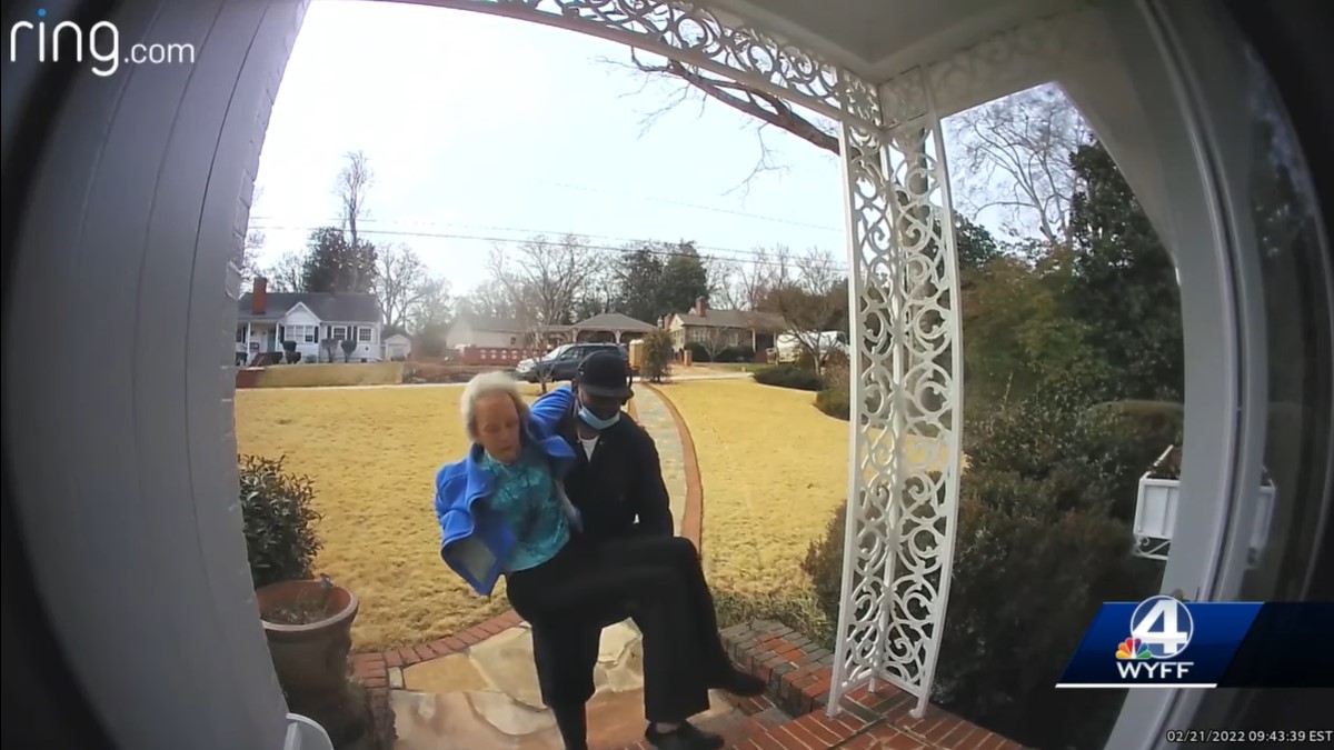 screenshot of ring doorbell camera footage of a man named fred austin walking up the front steps of a home as he carries an elderly woman who fell