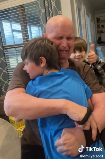 man cries while hugging his grandkids