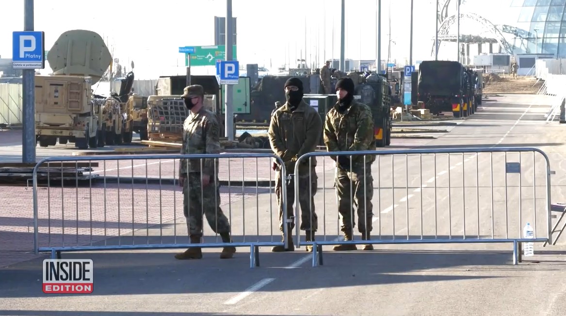 three ukrainian soldiers standing at a gate