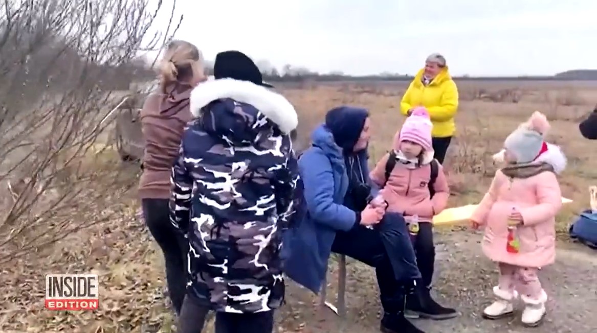 a group of ukrainian refugees on and near a bench in hungary 