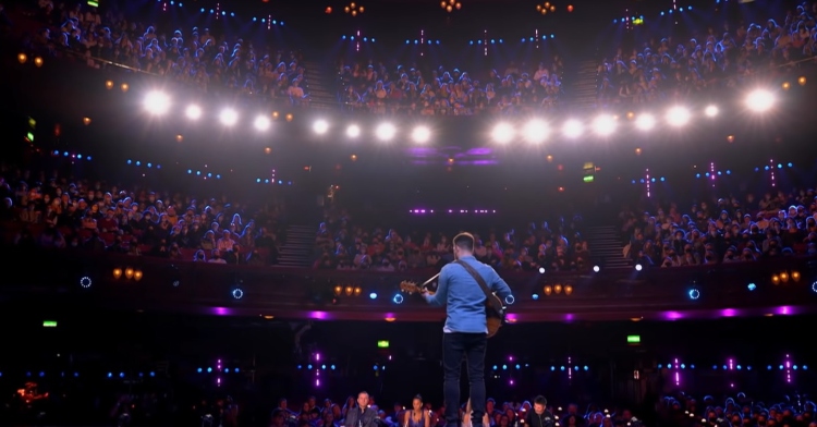 view from behind of nick edwards performing on the bgt stage.