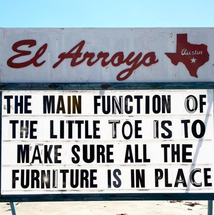 el arroyo marquee that reads "the main function of the little toe is to make sure all the furniture is in place."