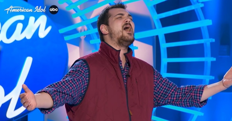 “american idol” contestant sam finelli closing his eyes and extending his arms as he passionately sings “rainbow” by kacey muscgraves for his “american idol” audition.