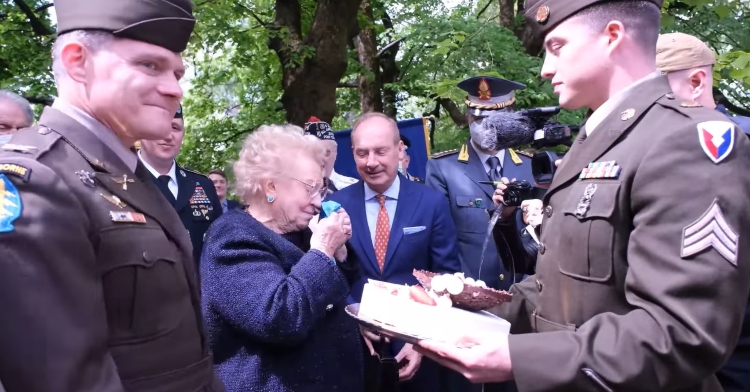 Meri Mion receiving her new cake from armed forces