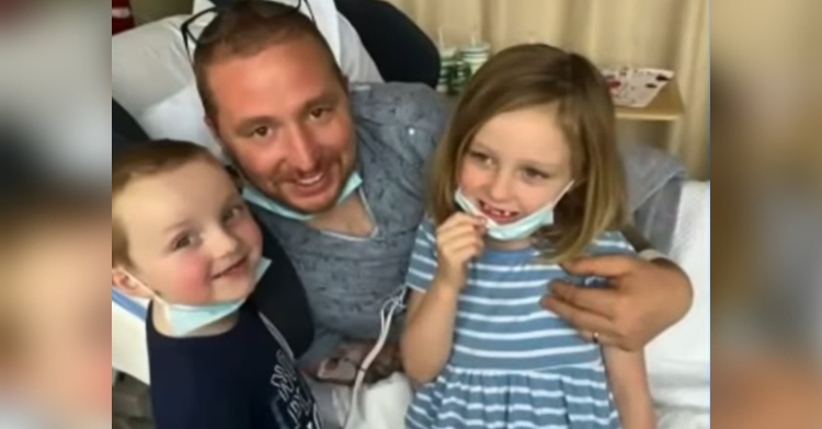 kyle semrau smiling as he lays in a hospital bed and poses with his kids.