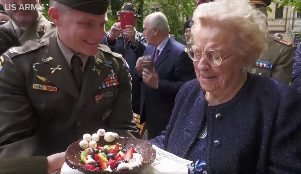 Army soldier giving Meri Mion her new cake