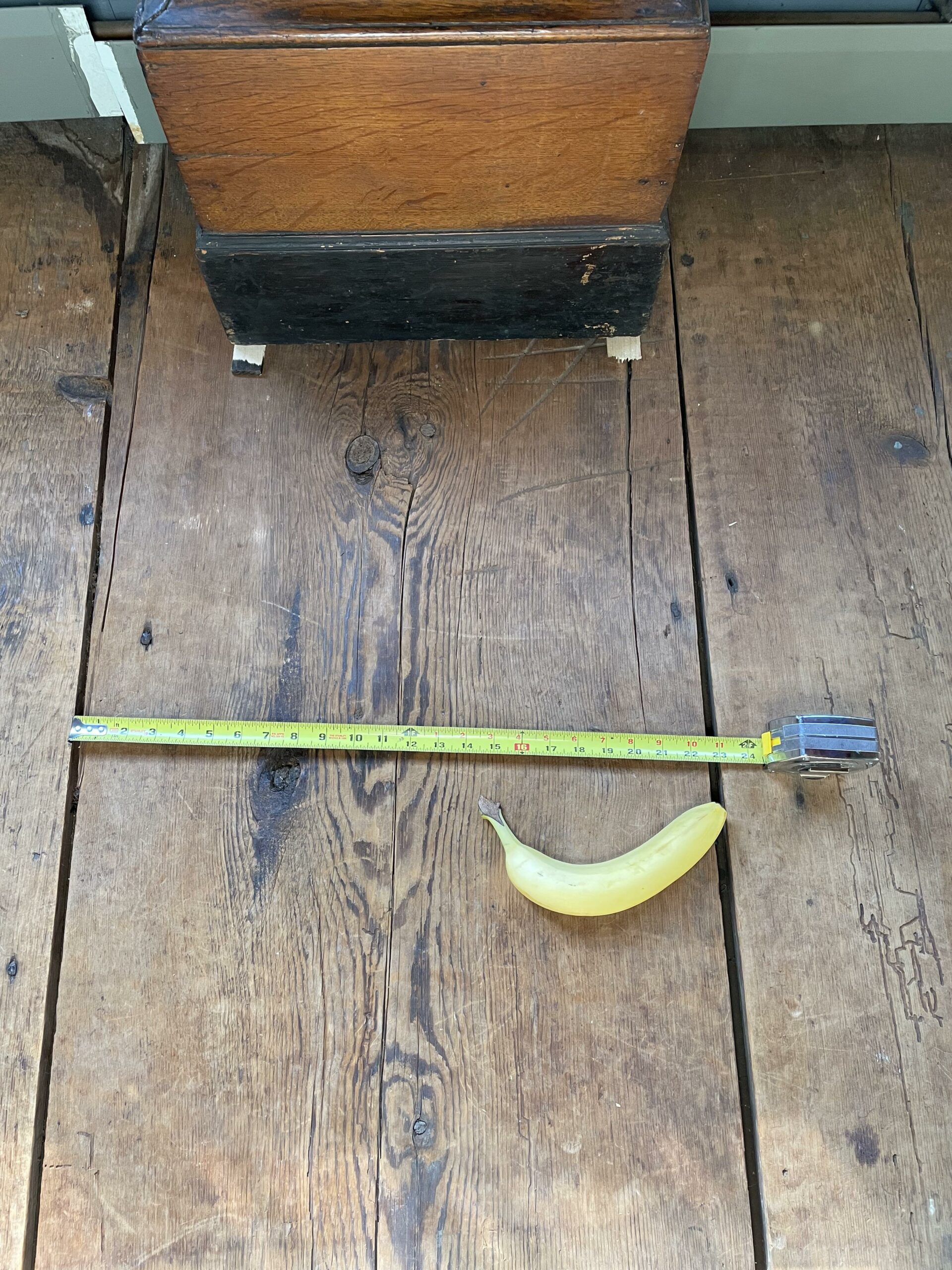 floorboards from the 1700s measured with a measuring tape and a banana